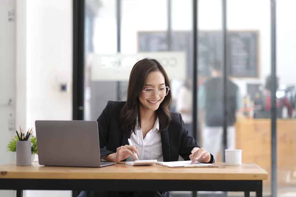 business owner works on a laptop overlooking charts