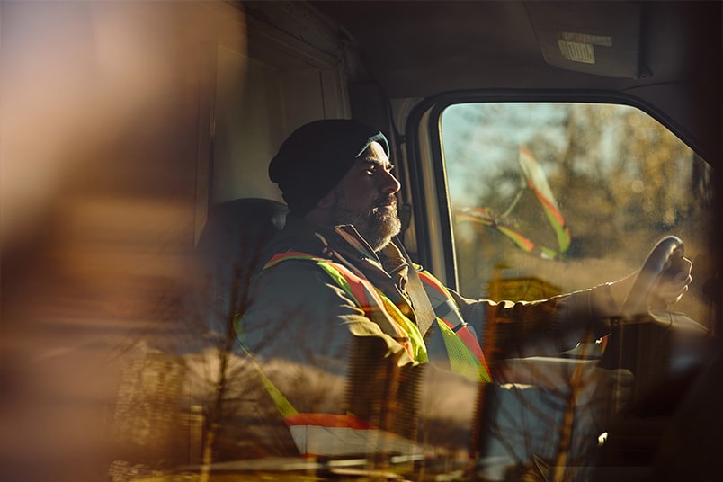 Commercial truck driver behind the wheel of a large semi-truck